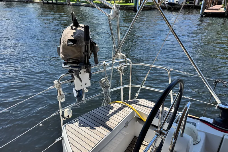 Slide: The Image of Jeanneau Sun Odyssey 44 DS sailboat deck, 2020 model, with steering wheel and water view. - 2