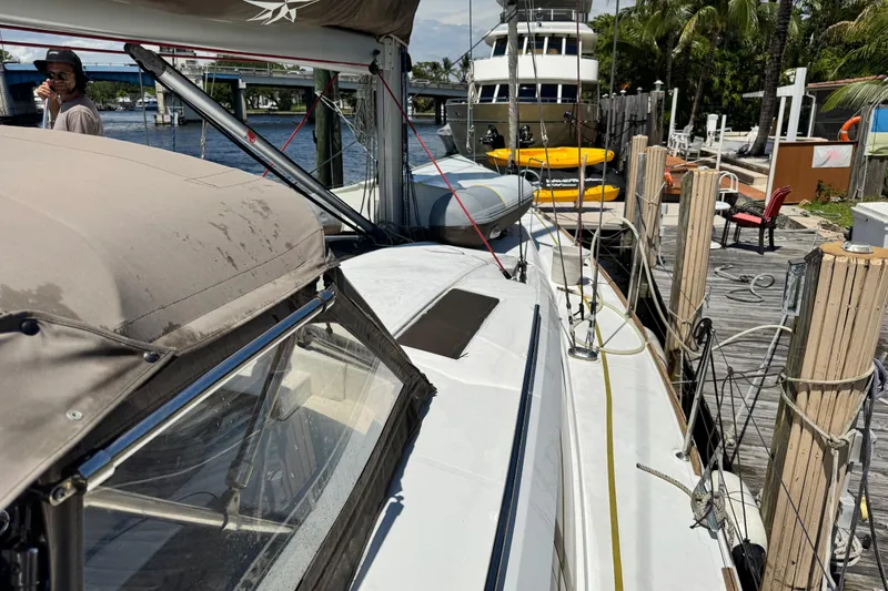 Slide: The Image of 2020 Jeanneau Sun Odyssey 44 DS docked, with kayaks and a person nearby. - 4