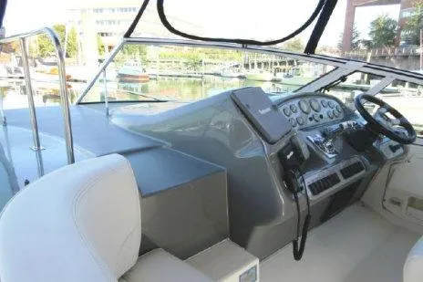 Slide: The Image of 2005 Cruisers Yachts 370 Express helm with modern controls and marina view. - 13