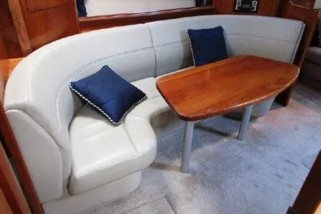 Slide: The Image of 2005 Cruisers Yachts 370 Express interior with curved seating and wooden table. - 18
