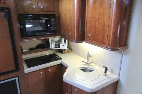 Slide: The Image of 2005 Cruisers Yachts 370 Express kitchen with wood cabinets, sink, and appliances. - 20