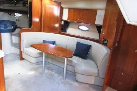 Slide: The Image of Interior of 2005 Cruisers Yachts 370 Express with curved seating and wooden table. - 26