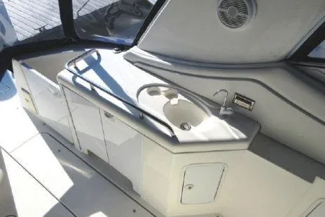 Slide: The Image of 2005 Cruisers Yachts 370 Express cockpit with sink and storage cabinets. - 9