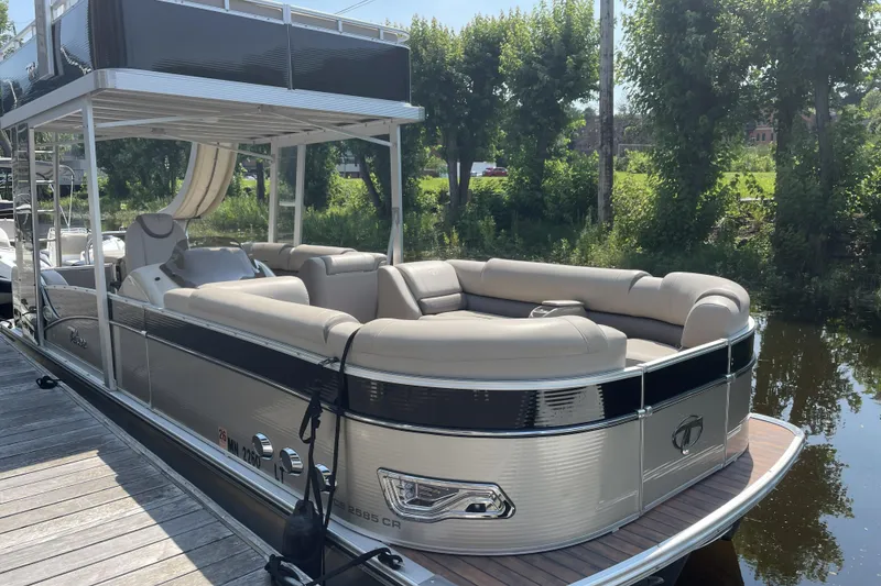 The Image of 2017 Tahoe Pontoon Cascade Platinum Funship Cruise, 25-foot luxury boat docked by lush greenery. - 0