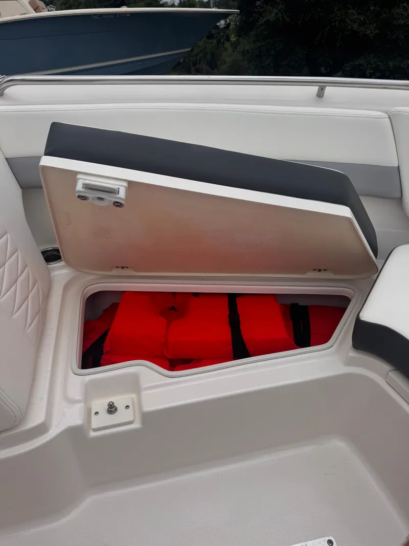 Slide: The Image of 2023 Robalo R247 Dual Console with open storage compartment and life jackets. - 17