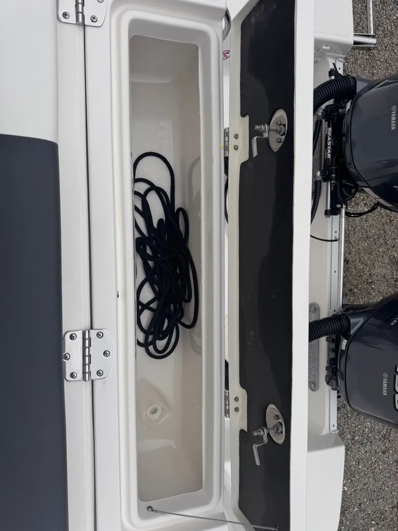 Slide: The Image of 2023 Robalo R247 Dual Console with storage compartment and engines. - 26