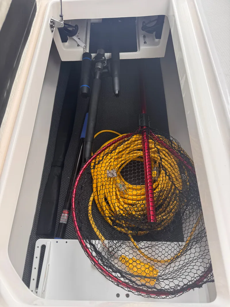 Slide: The Image of Storage compartment in Robalo R247 with fishing rods and net. - 28