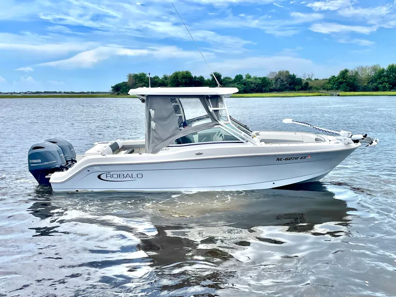 Slide: The Image of 2023 Robalo R247 Dual Console boat on calm water. - 5