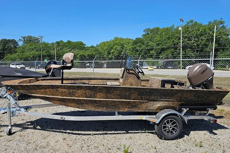 The Image of 2026 G3 Gator Tough 17 CC boat on trailer, camo design, Yamaha motor, outdoor setting. - 0