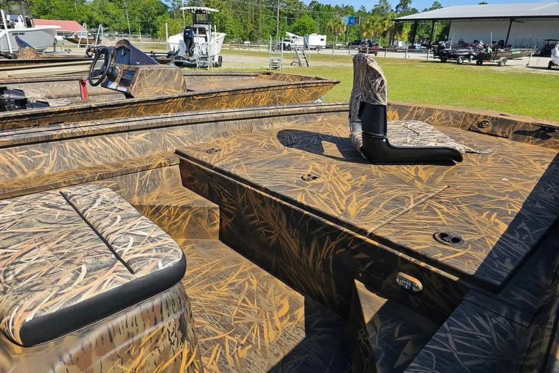 Slide: The Image of 2026 G3 Gator Tough 17 CC boat with camouflage interior, parked outdoors. - 12