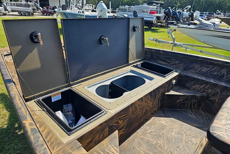 Slide: The Image of 2026 G3 Gator Tough 17 CC boat with open storage compartments and camouflage interior. - 14