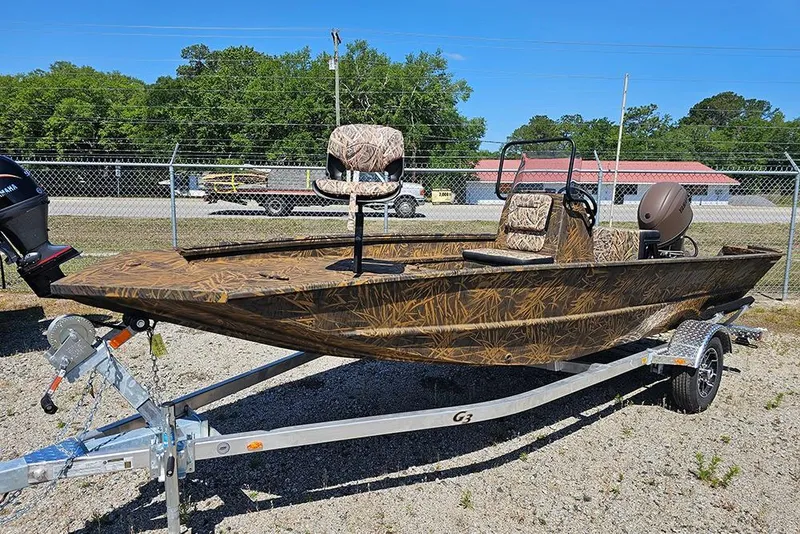 Slide: The Image of 2026 G3 Gator Tough 17 CC boat on trailer, camo design, parked outdoors. - 19