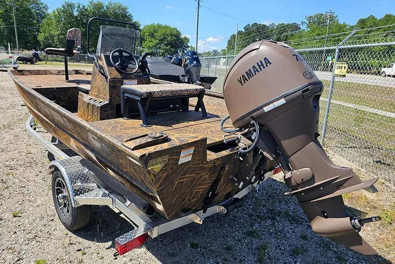Slide: The Image of 2026 G3 Gator Tough 17 CC boat on trailer, camo design, parked outdoors. - 20