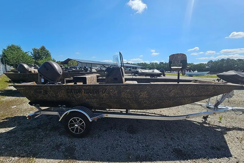 Slide: The Image of 2026 G3 Gator Tough 17 CC boat on trailer, camo design, parked outdoors. - 24