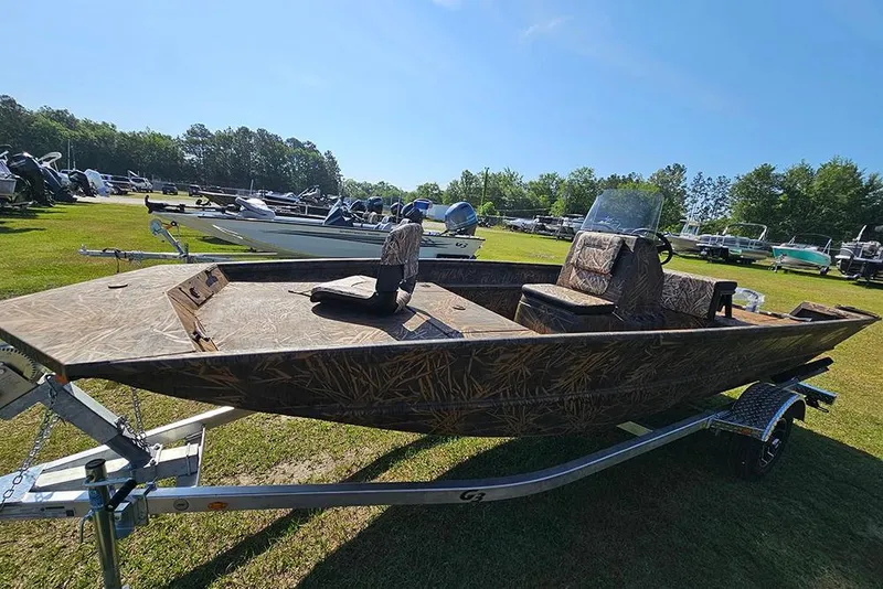 Slide: The Image of 2026 G3 Gator Tough 17 CC boat on trailer, camo design, parked outdoors. - 6