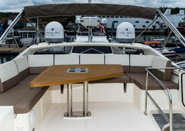 Slide: The Image of Flybridge seating area on a 2014 Prestige 550 Fly yacht with a wooden table. - 10