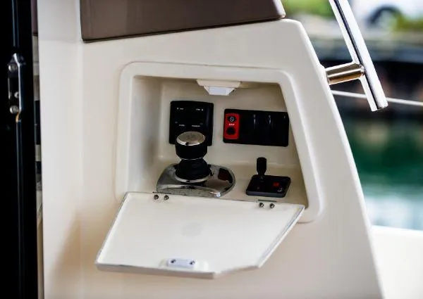 Slide: The Image of Control panel of a 2014 Prestige 550 Fly yacht, featuring switches and a joystick. - 14