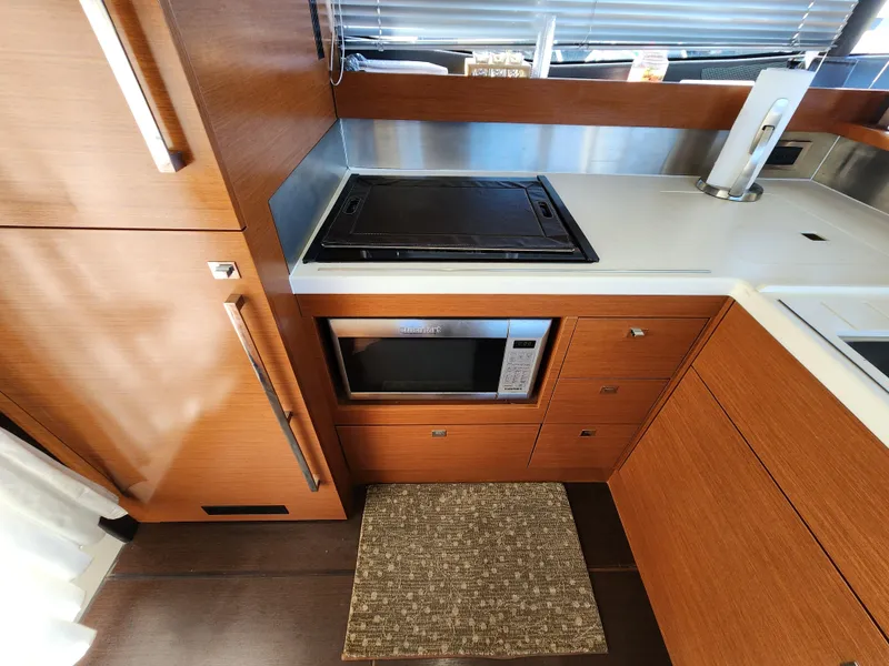 Slide: The Image of Modern kitchen in 2014 Prestige 550 Fly yacht with stove, microwave, and wooden cabinetry. - 18
