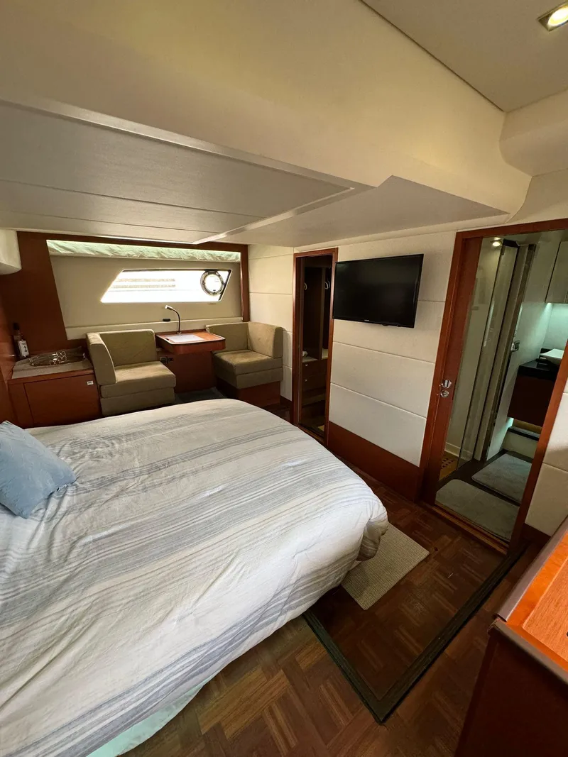 Slide: The Image of Luxurious interior of a 2014 Prestige 550 Fly yacht, featuring a cozy bedroom and seating area. - 31