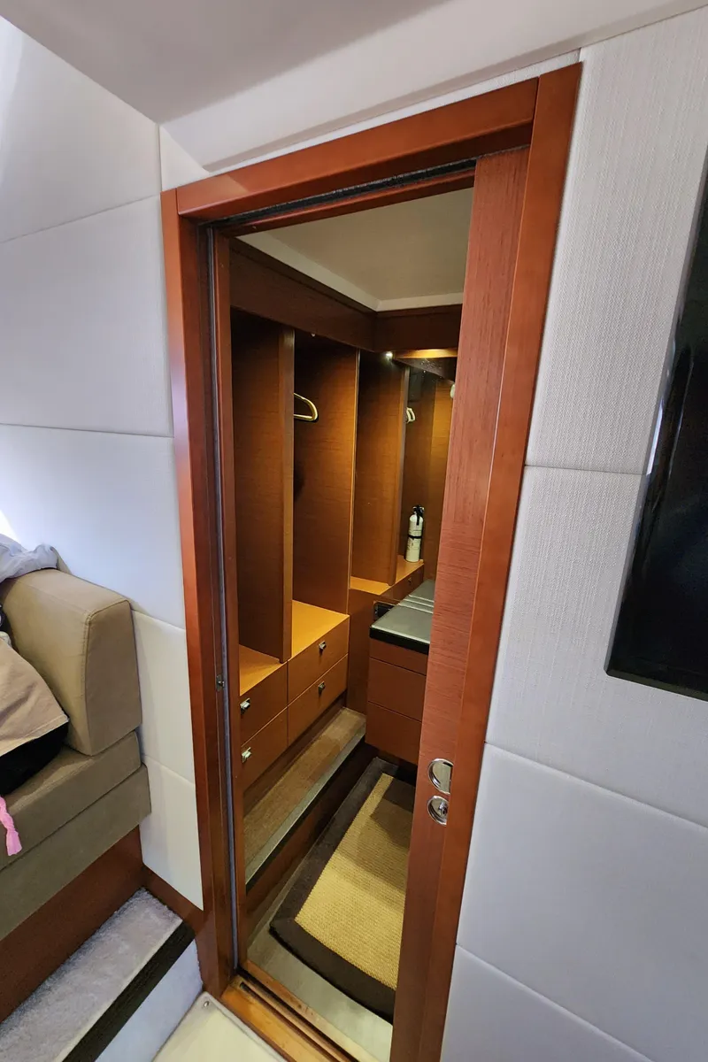 Slide: The Image of Interior view of 2014 Prestige 550 Fly yacht, featuring a wooden door and cozy cabin space. - 42