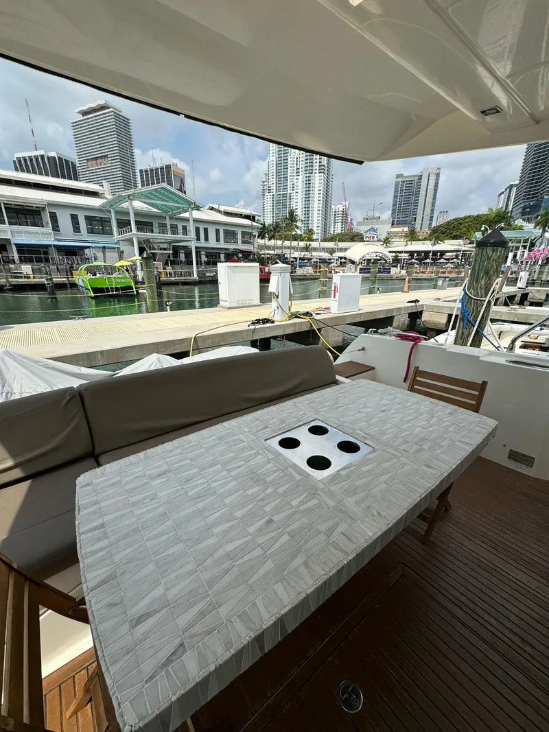 Slide: The Image of Prestige 550 Fly 2014 yacht with marina view, featuring a covered outdoor seating area. - 7
