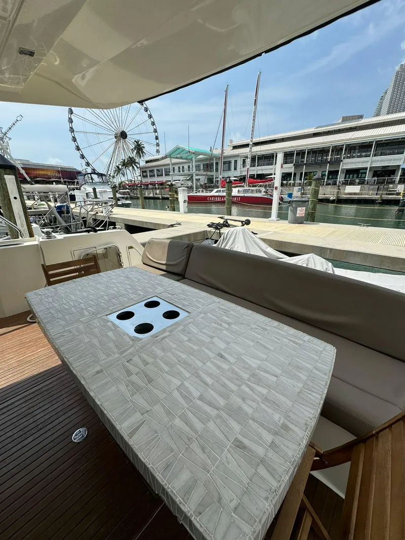 Slide: The Image of Luxurious 2014 Prestige 550 Fly yacht with spacious deck, docked at marina with Ferris wheel view. - 8