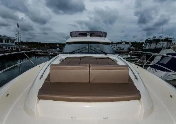 Slide: The Image of 2014 Prestige 550 Fly yacht with cushioned deck, docked under cloudy skies. - 9