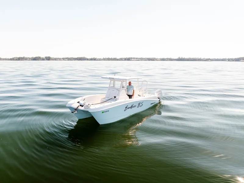 Slide: The Image of 2023 Twin Vee 260 GFX CC boat on calm water. - 2