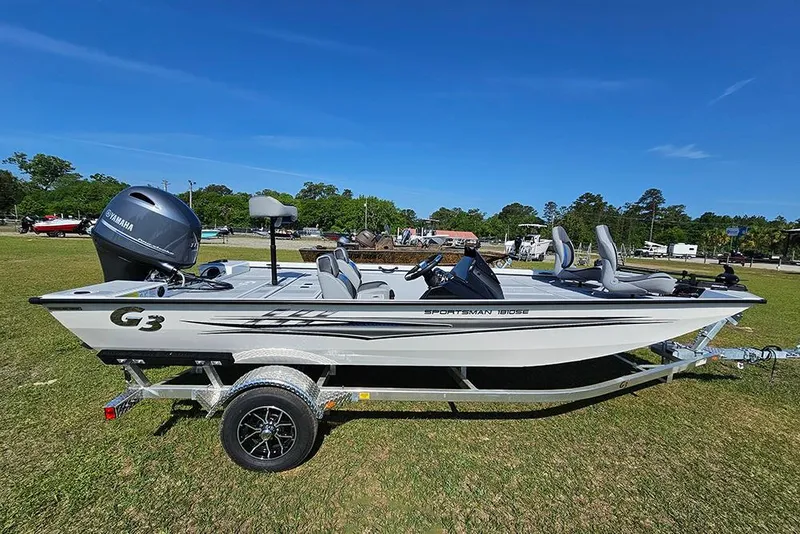 The Image of 2026 G3 Sportsman 1810 SE boat on trailer, parked on grass under clear blue sky. - 1