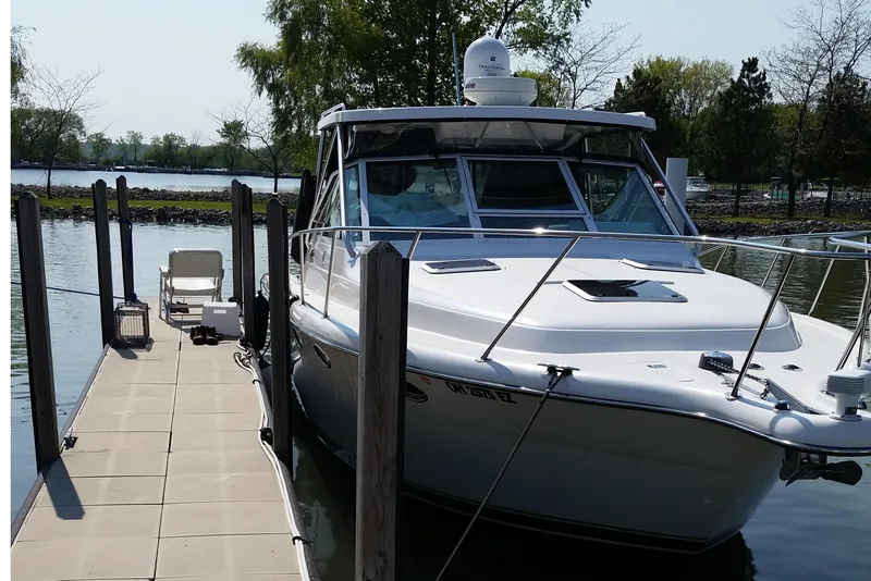 Slide: The Image of 2003 Tiara Yachts 3100 Open LE docked at a serene marina. - 3