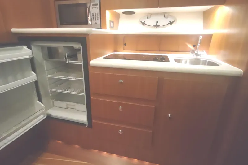 Slide: The Image of 2003 Tiara Yachts 3100 Open LE galley with fridge, microwave, stove, and sink. - 33