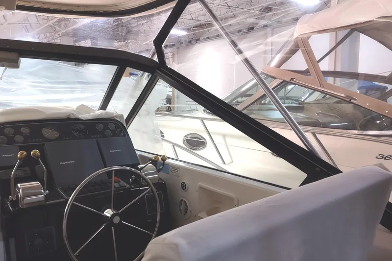 Slide: The Image of 2003 Tiara Yachts 3100 Open LE helm with navigation equipment in a marina setting. - 5