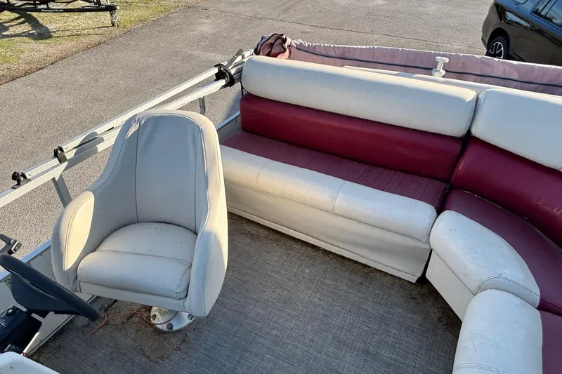 Slide: The Image of Interior of a 2000 JC Manufacture 24 Dolphin boat with white and maroon seating. - 7