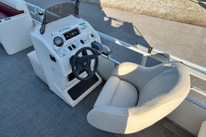 Slide: The Image of Steering console of a 2000 JC Manufacture 24 Dolphin boat with cushioned seat. - 8