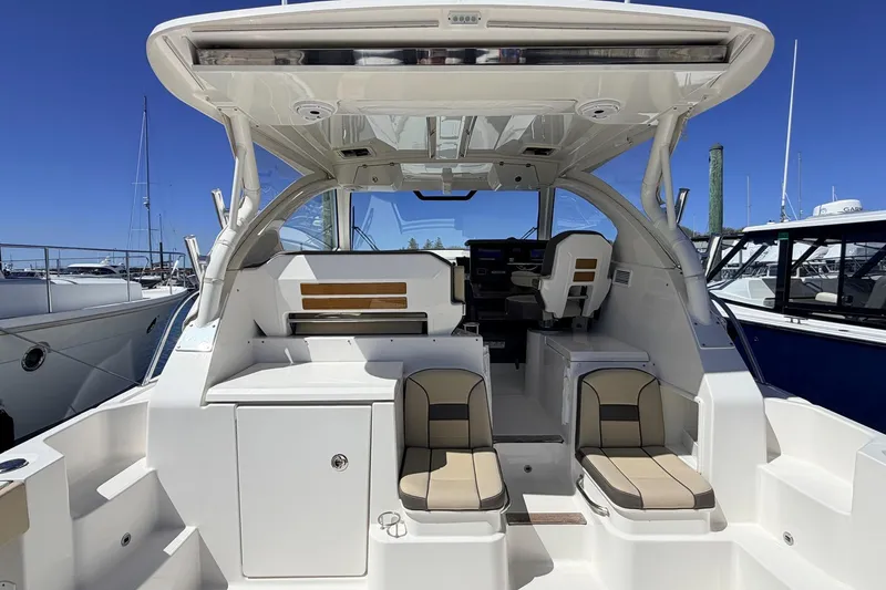 Slide: The Image of 2020 Pursuit OS 355 Offshore boat interior with seating and helm, docked at marina. - 15