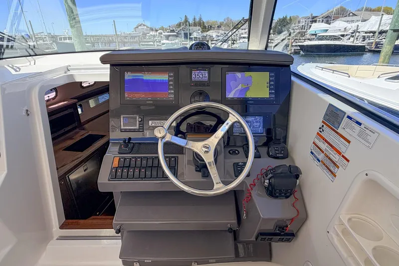 Slide: The Image of Helm of 2020 Pursuit OS 355 Offshore boat with navigation screens and controls. - 17