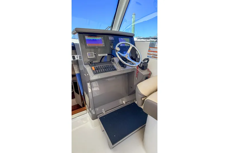 Slide: The Image of Helm of 2020 Pursuit OS 355 Offshore boat with steering wheel and navigation controls. - 18