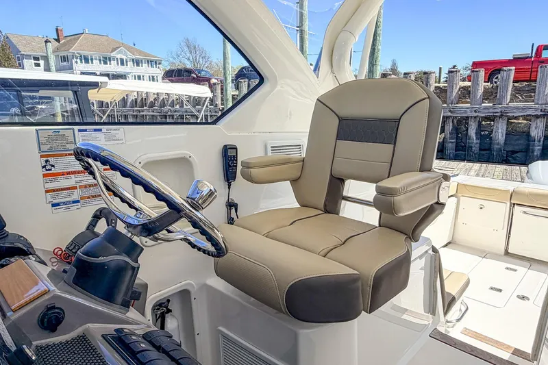 Slide: The Image of Captain's chair and helm of 2020 Pursuit OS 355 Offshore boat, docked at marina. - 19