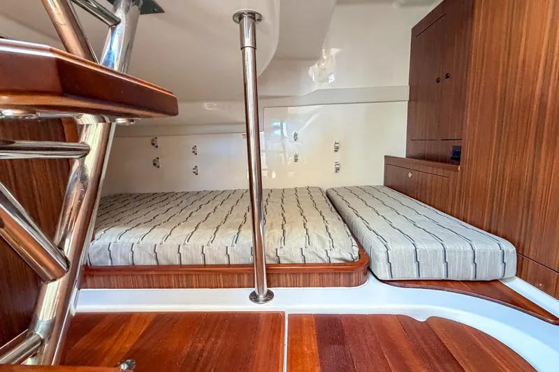 Slide: The Image of 2020 Pursuit OS 355 Offshore cabin interior with wooden finishes and striped bedding. - 28