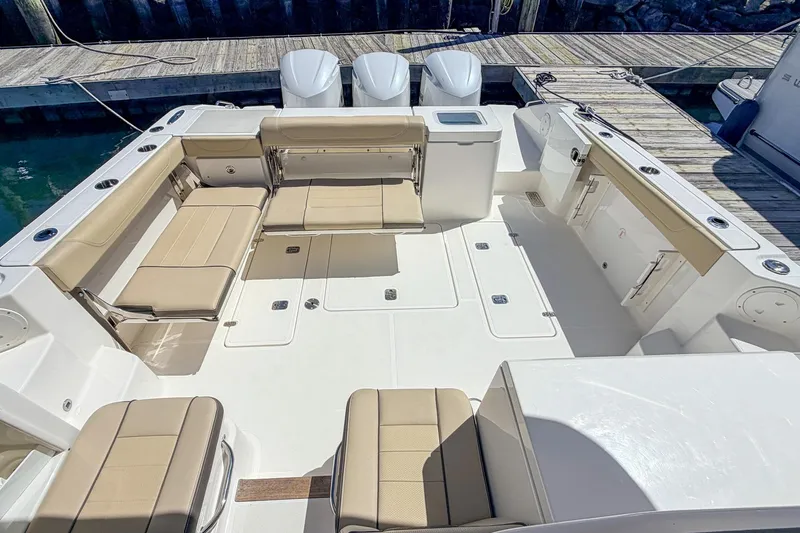 Slide: The Image of 2020 Pursuit OS 355 Offshore boat with spacious seating and triple outboard engines. - 7