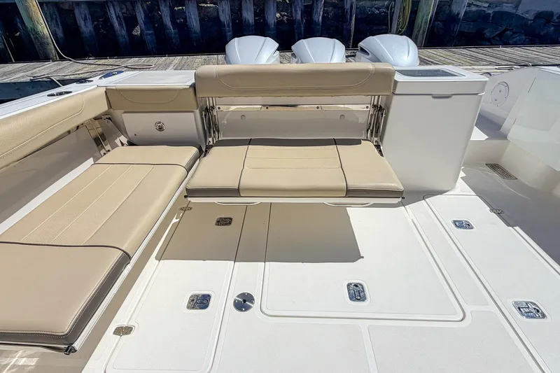 Slide: The Image of 2020 Pursuit OS 355 Offshore boat interior with beige seating and storage compartments. - 8