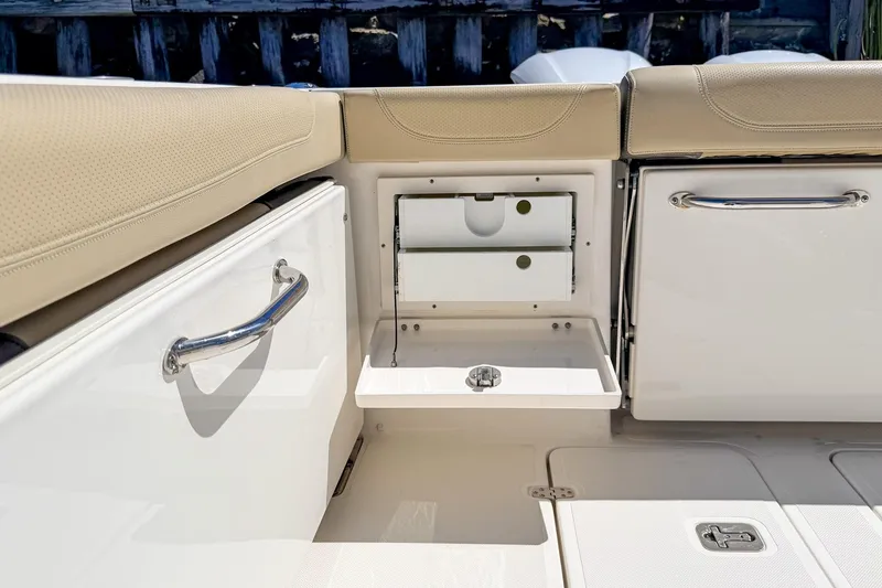 Slide: The Image of 2020 Pursuit OS 355 Offshore boat interior storage compartments with beige seating. - 9