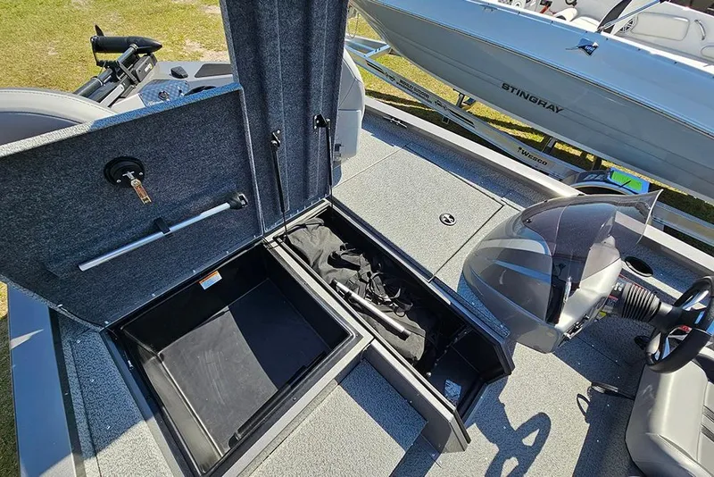 Slide: The Image of 2026 G3 Sportsman 1710 boat interior with open storage compartments and steering console. - 21