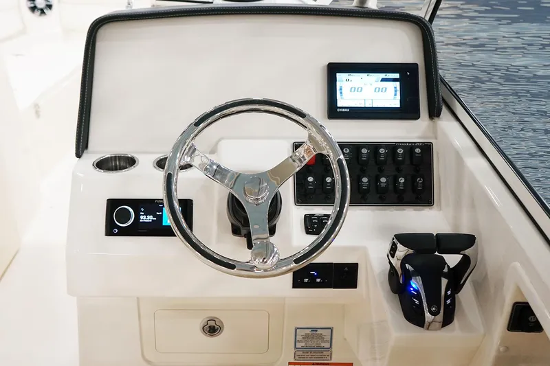 Slide: The Image of Manufacturer Provided Image: 2023 Grady-White Freedom 285 boat dashboard with steering wheel and electronic controls. - 9