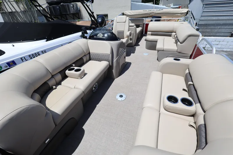 Slide: The Image of 2023 SUNTRACKER PB 22DLX pontoon boat with beige seating and cup holders. - 13