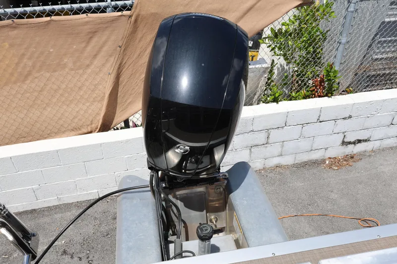 Slide: The Image of 2023 SUNTRACKER PB 22DLX boat engine, parked outdoors near a chain-link fence. - 18