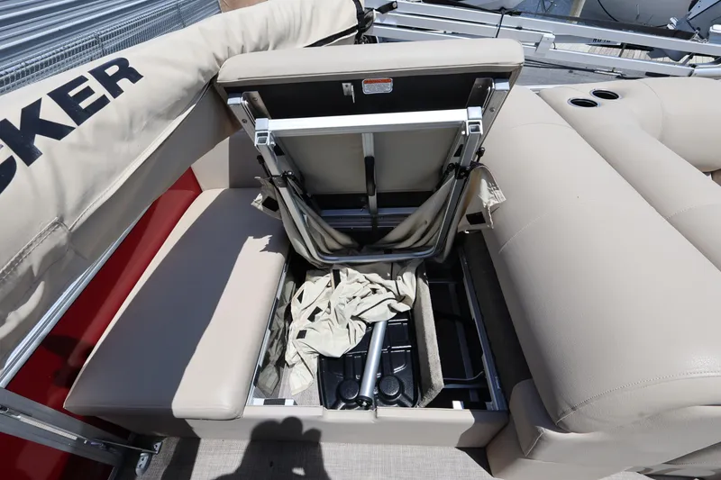 Slide: The Image of 2023 SUNTRACKER PB 22DLX pontoon boat with open storage compartment and beige seating. - 19