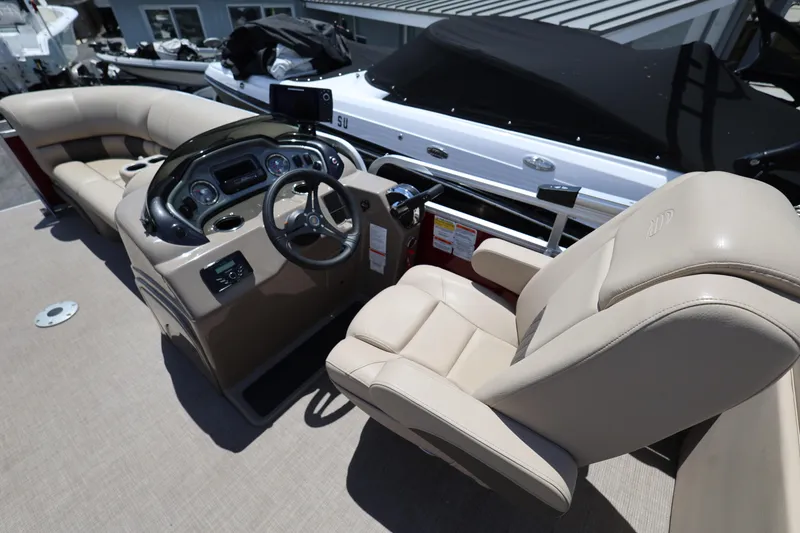 Slide: The Image of 2023 SUNTRACKER PB 22DLX boat interior with steering console and beige seating. - 21