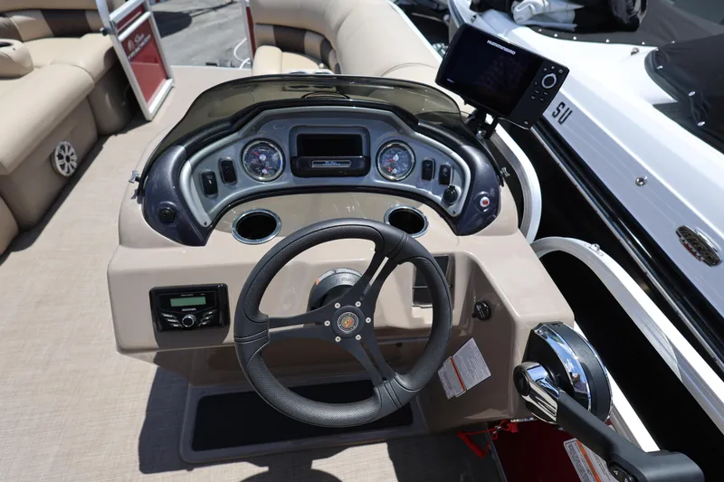 Slide: The Image of 2023 SUNTRACKER PB 22DLX boat dashboard with steering wheel and control panel. - 22