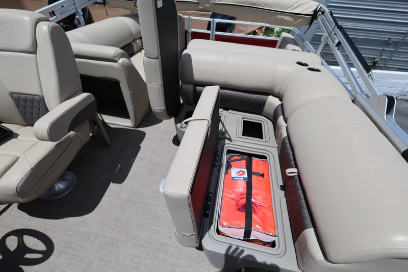 Slide: The Image of 2023 SUNTRACKER PB 22DLX pontoon boat interior with beige seating and storage compartments. - 25